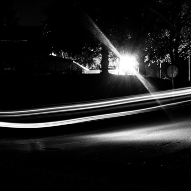 Black and white extended exposure photograph of car light trail in woods in Huntingdon, Pennsylvania
