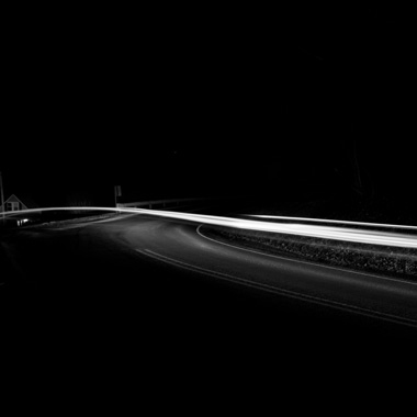 Black and white extended exposure photograph of car light trail in woods in York, Pennsylvania