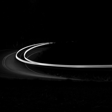 Black and white extended exposure photograph of car light trail in woods in York, Pennsylvania